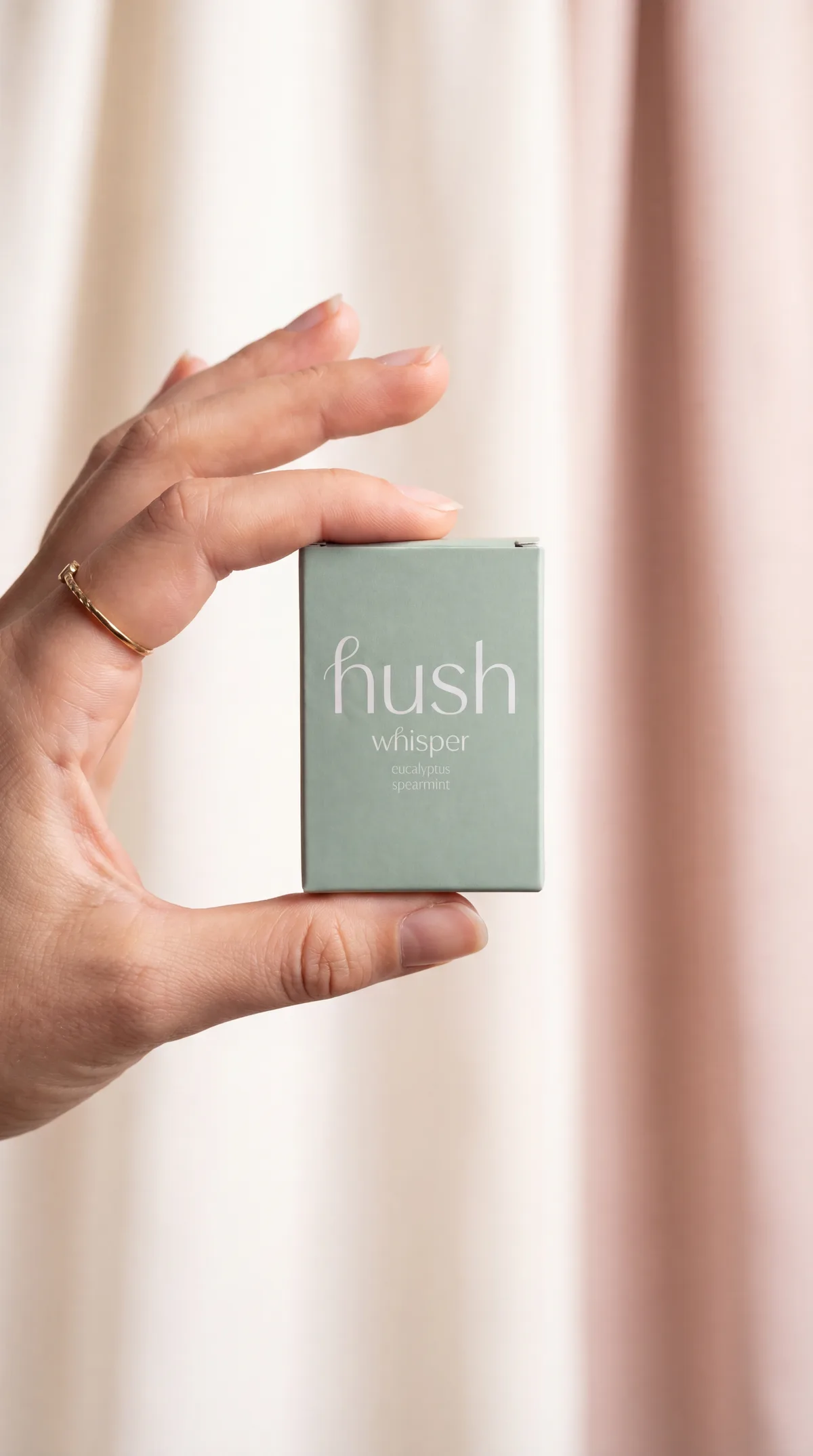 Hush bottle held between fingers